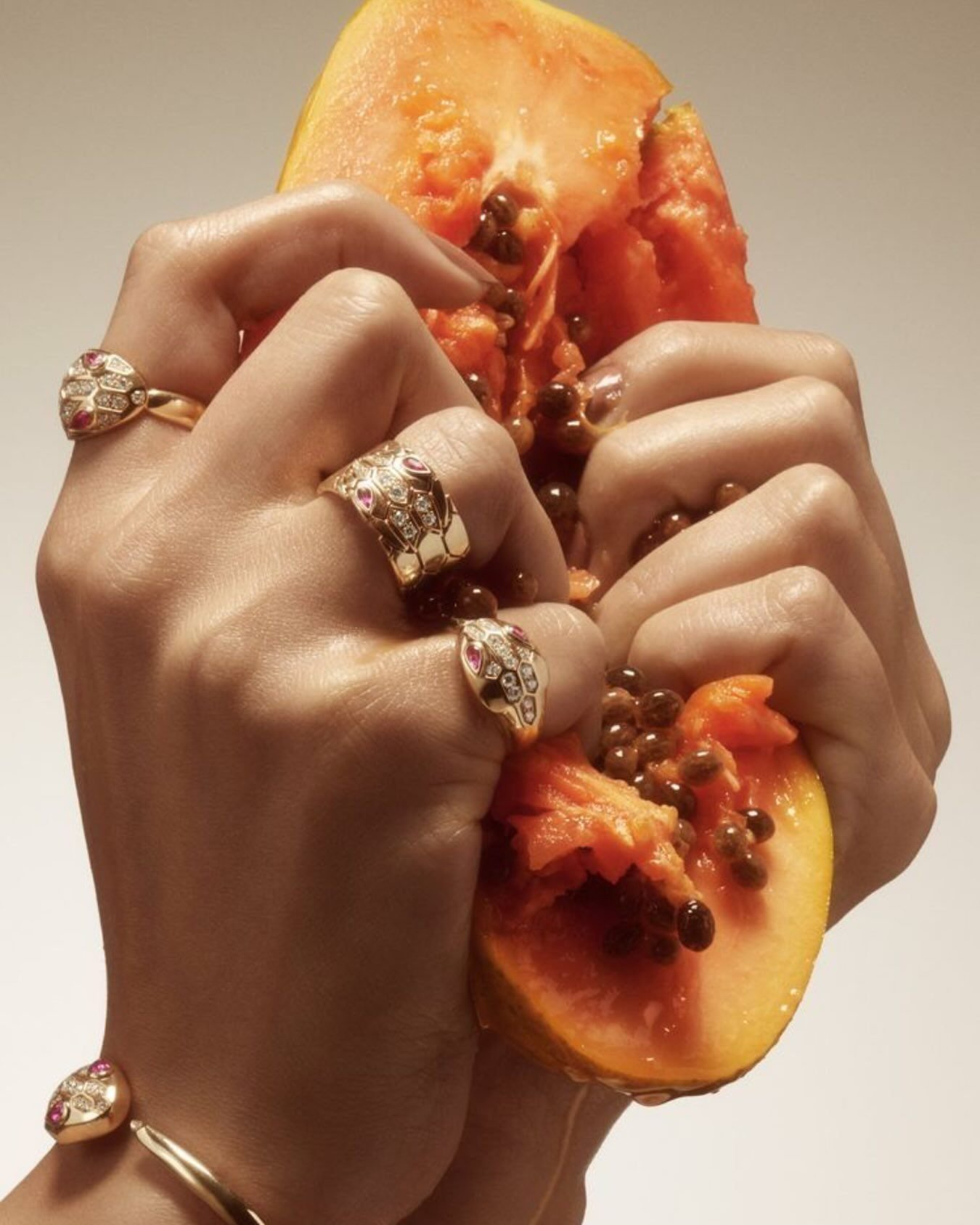 Manos con anillos y papaya
